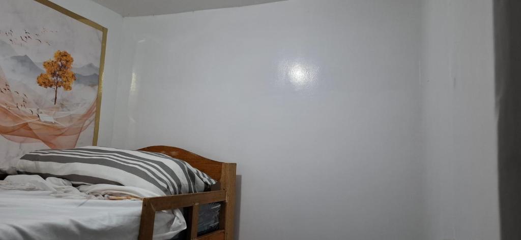 a bedroom with a bed and a painting on the wall at Lowest Price Room In Chinatown Davao with WiFi Room 1 in Davao City