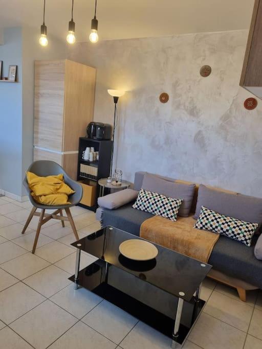 un salon avec un canapé et une chaise dans l'établissement appartement agréable, à Guérande