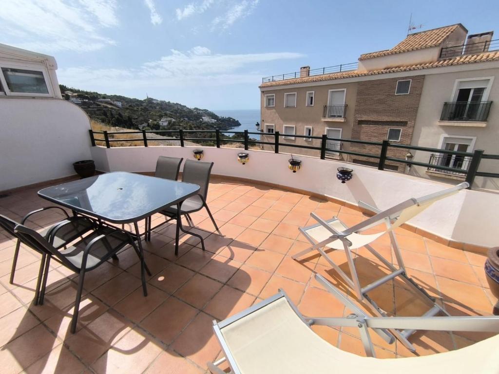 a patio with a table and chairs on a balcony at Casa Cati in La Herradura