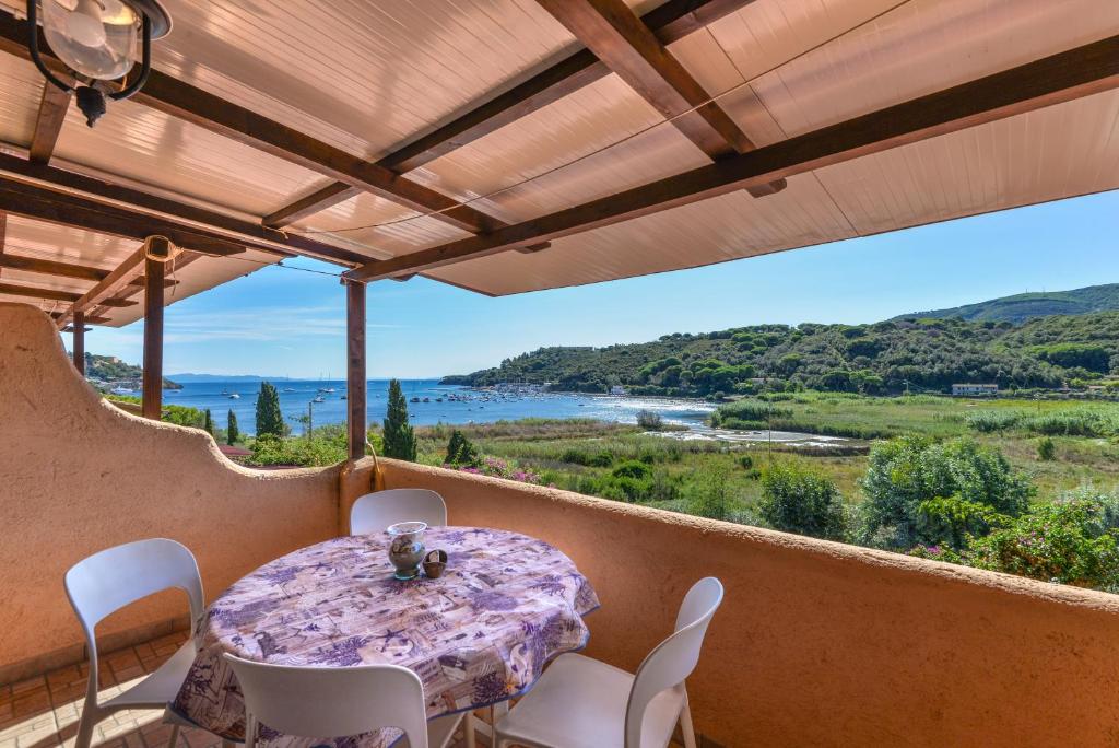 a table and chairs on a balcony with a view at Mono4Posti Vista Mare Il Portolano in Porto Azzurro