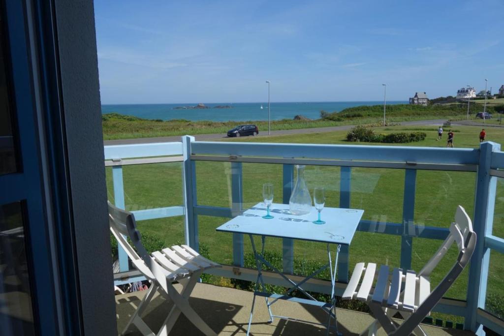 une table et des chaises sur un balcon avec vue sur l'océan dans l'établissement Nice T3 with terrace and sea view, à Saint-Malo