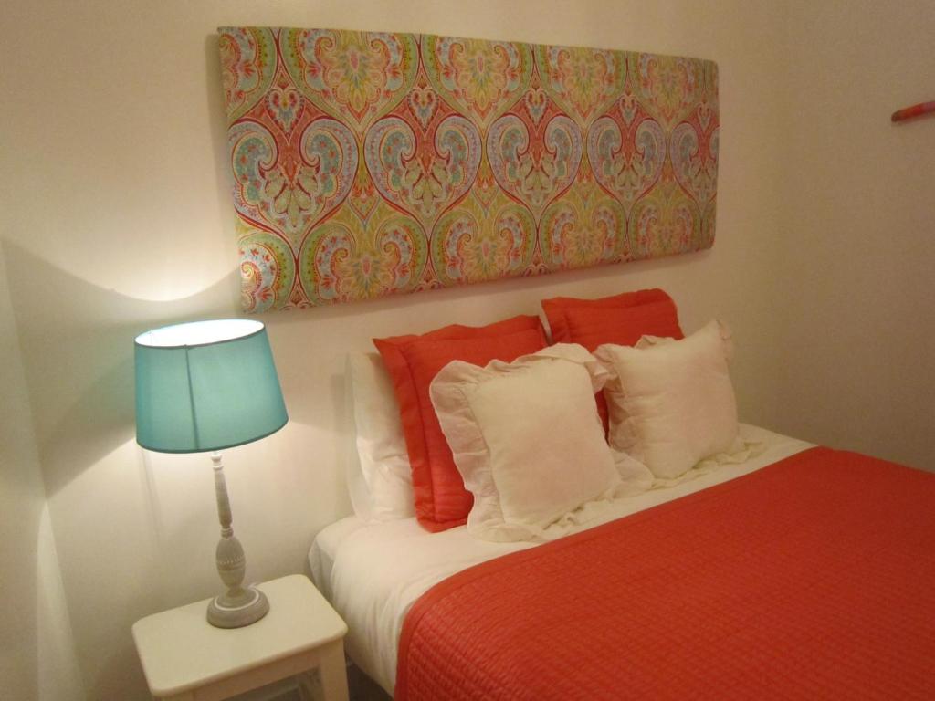 a bedroom with a bed with a lamp and a painting at Alfama Shabby Chic Flat in Lisbon