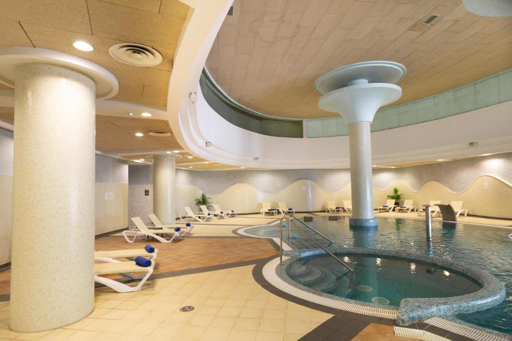 a pool in a hotel lobby with a swimming pool at R2 Hotel Pajara Beach in Costa Calma