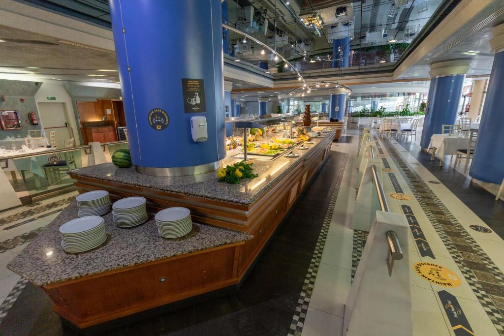 a restaurant with a buffet line with plates on display at R2 Hotel Pajara Beach in Costa Calma