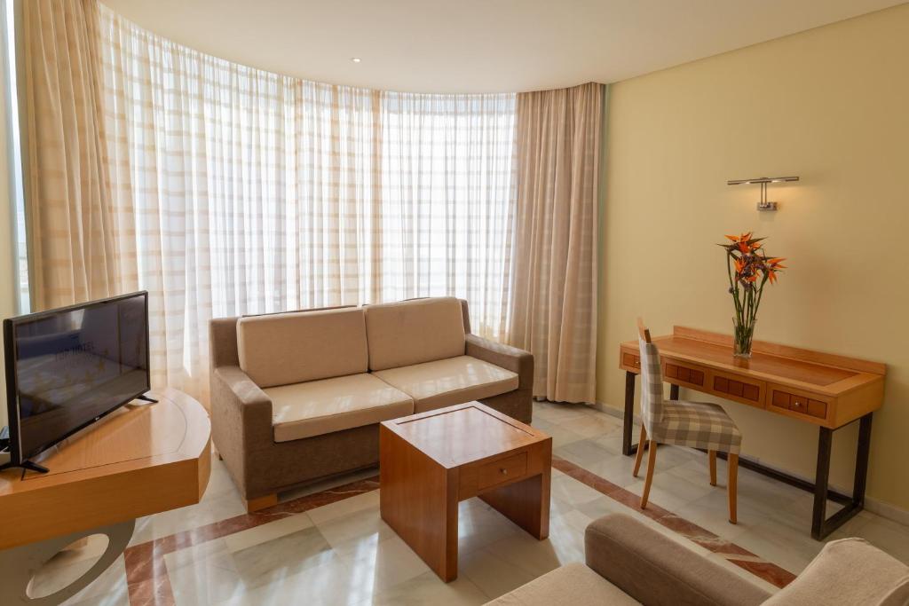a living room with a couch and a television at R2 Hotel Pajara Beach in Costa Calma