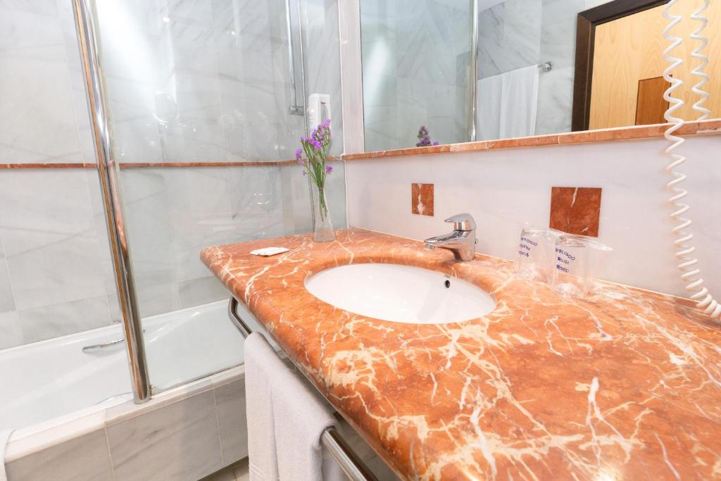 a bathroom with a marble sink and a shower at R2 Hotel Pajara Beach in Costa Calma