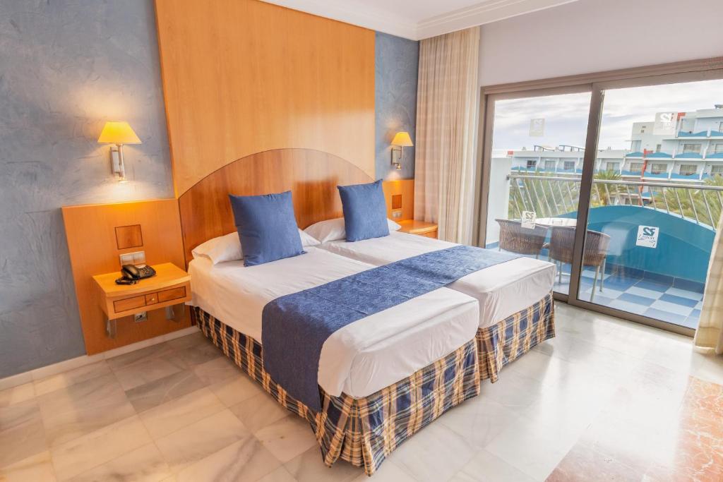 a hotel room with a bed and a balcony at R2 Hotel Pajara Beach in Costa Calma