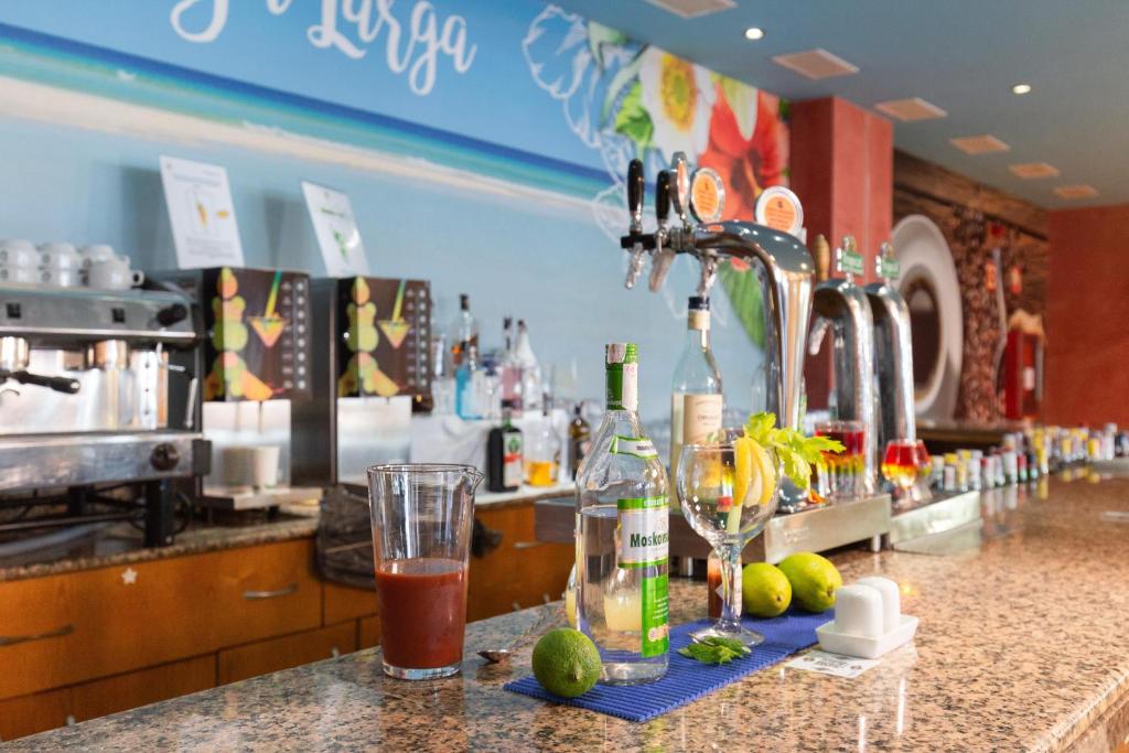 a bar with bottles and glasses on a counter at R2 Hotel Pajara Beach in Costa Calma