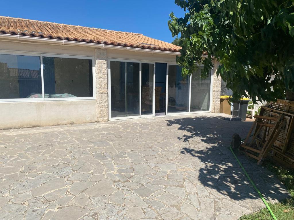 une terrasse d'une maison avec des fenêtres et un arbre dans l'établissement Villa Mazari, à Orange