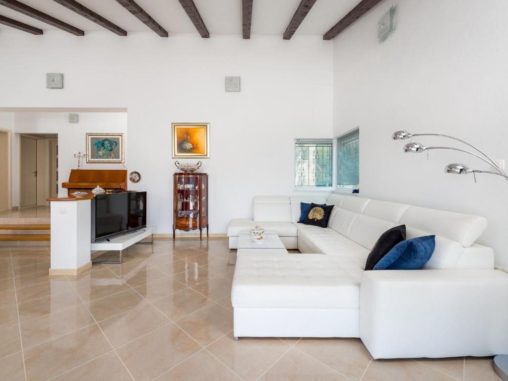 a white living room with a white couch and a television at Villa Dea - Luxury Villa with Outdoor Swimming Pool in Vučevica