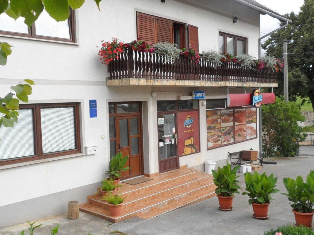 a building with a balcony with flowers on it at Apartments & Rooms Renduli - One Bedroom Apartment with Balcony in Rakovica