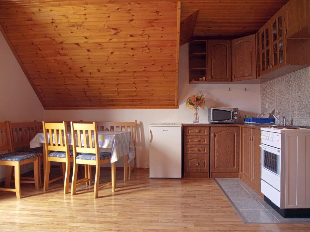 a kitchen with a table and a white refrigerator at Guesthouse afran- Two Bedroom Apartment in Plitvička Jezera