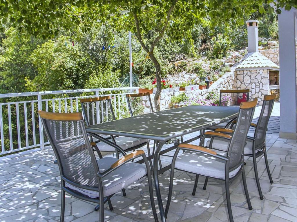 une table et des chaises vertes sur la terrasse dans l'établissement Apartments Vesela - One Bedroom Apartment with Balcony and Sea View, à Janjina