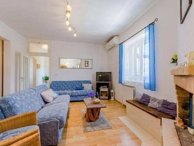 a living room with a blue couch and a fireplace at Apartment Blue Oasis - Three Bedroom Apartment ST in Postira