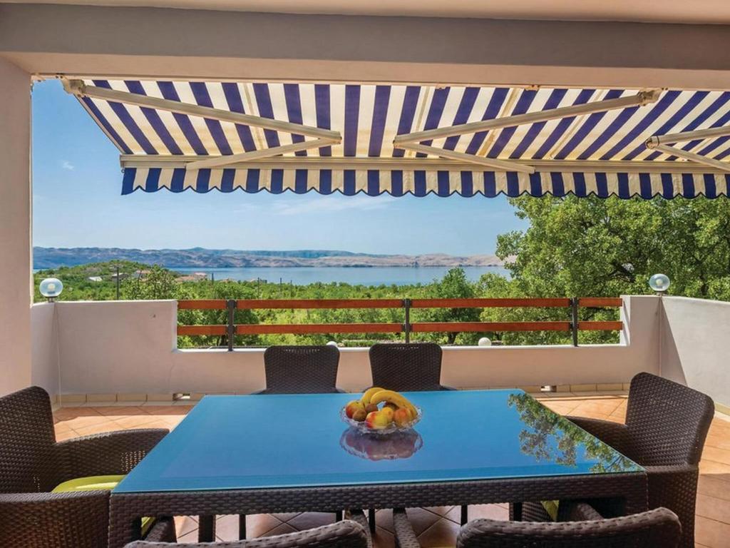 カルロバッグにあるApartments Paola - Two Bedroom Apartment with Terrace and Sea viewの青いテーブルと椅子が備わる眺めの良いパティオ