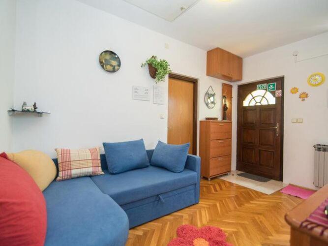 スペタルにあるApartments Natasa- One Bedroom Apartment with Balcony A1 - STの青いソファとキッチンのあるリビングルーム