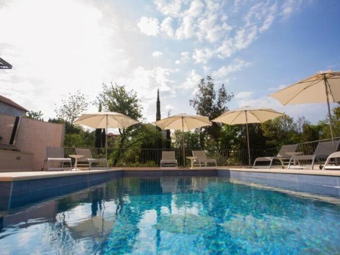 una piscina con sillas y sombrillas en Apartments Villa Lukas - ''No 5'' One-Bedroom Apartment with Balcony and Sea View, en Cavtat