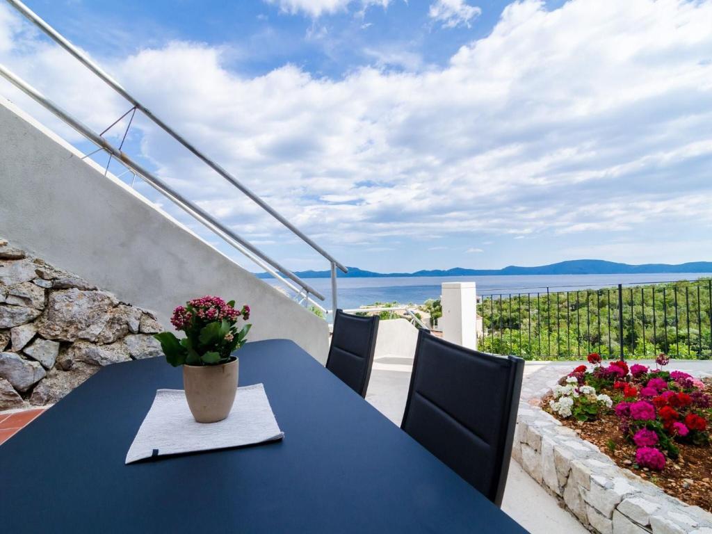 a blue table with a vase of flowers on a balcony at 3 Bedroom villa with terrace and pool in Zaton Doli