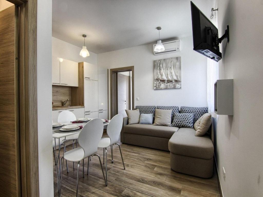 a living room with a couch and a table and chairs at Apartments Victoria - One Bedroom Apartment with Terrace A2 in Pakoštane