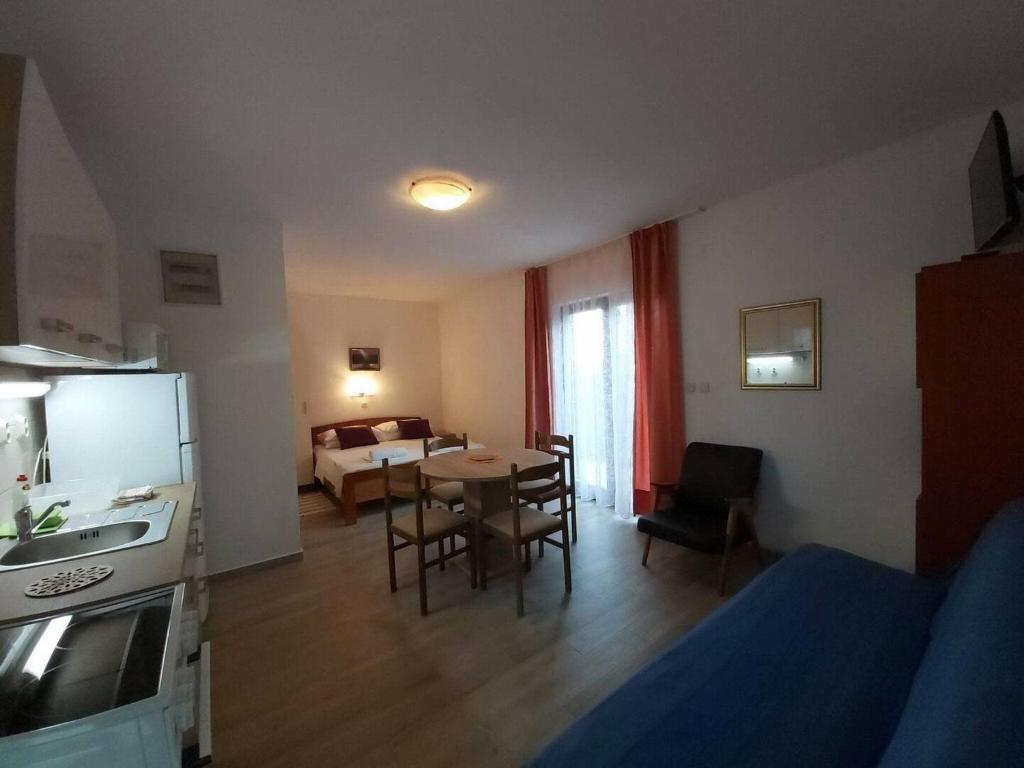 a kitchen and a living room with a table and chairs at Apartments Villa Pelegrin - Studio Apartment with Sea View Apartment in Zavala