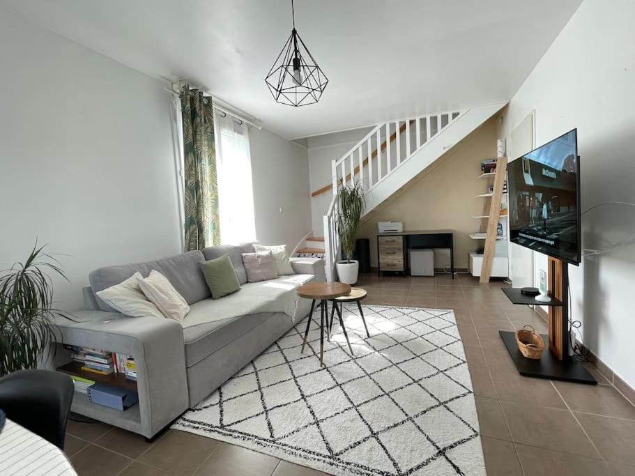 a living room with a couch and a staircase at Disney en famille&Appart Calme et Spacieux in Magny-le-Hongre