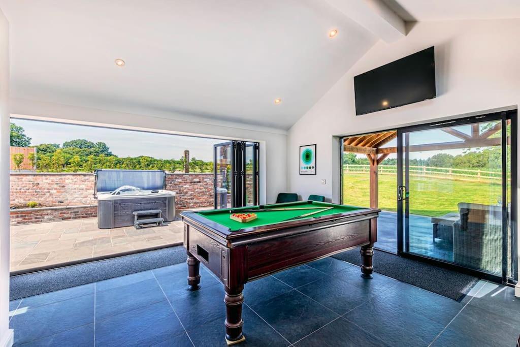 a living room with a pool table and a patio at Fairvale House in Winsford