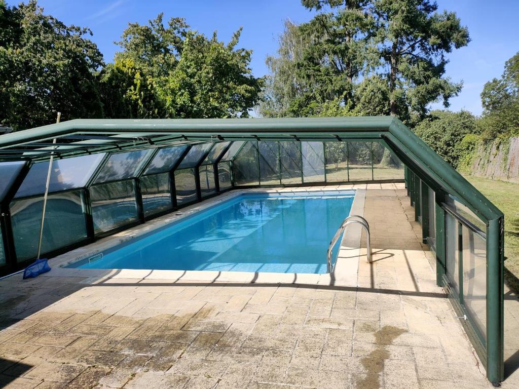 a swimming pool with a glass bridge over it at maison de campagne toute équipée 5km de Thoiry in Saulx-Marchais
