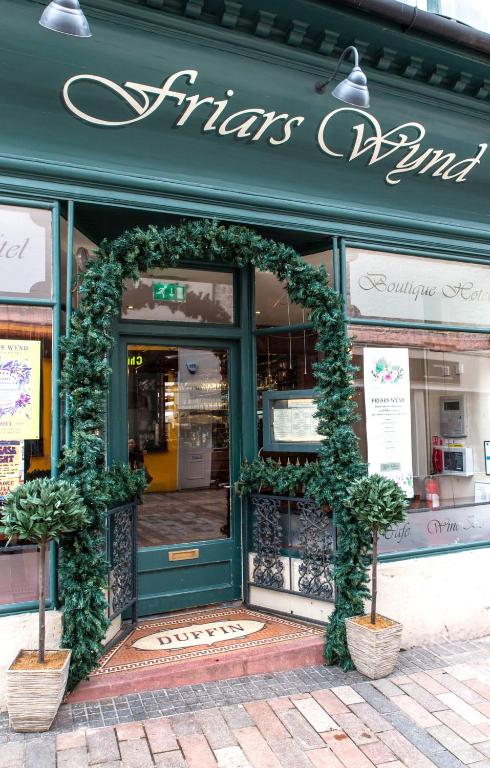 a store front with a green door with plants on it at Friars Wynd Guest Rooms in Stirling