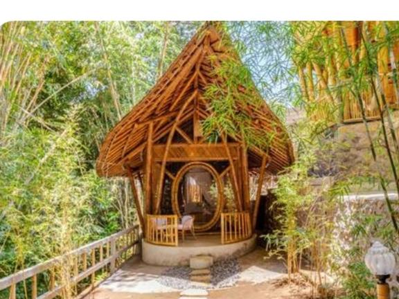 una piccola capanna con tetto di paglia in una foresta di Bamboohouse pondok salacca #salacca inn a Manggis