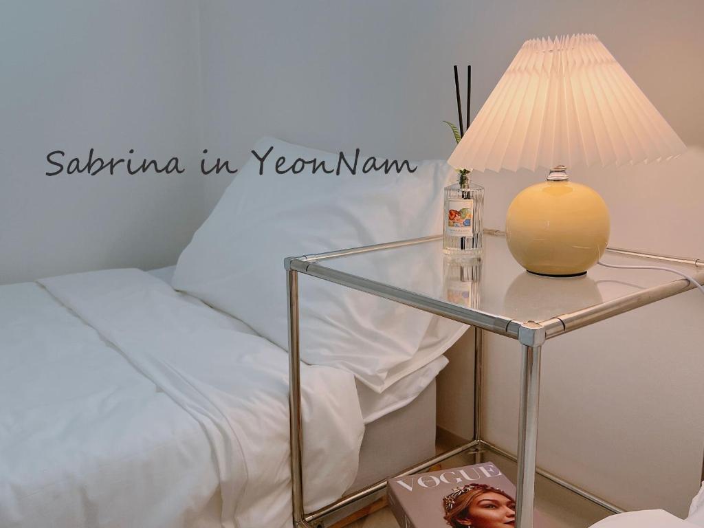首尔#New #Seoul #Hongdae #3BDS #1BA #private #1FL Sabrina in YeonNam的一张玻璃桌,床边有灯