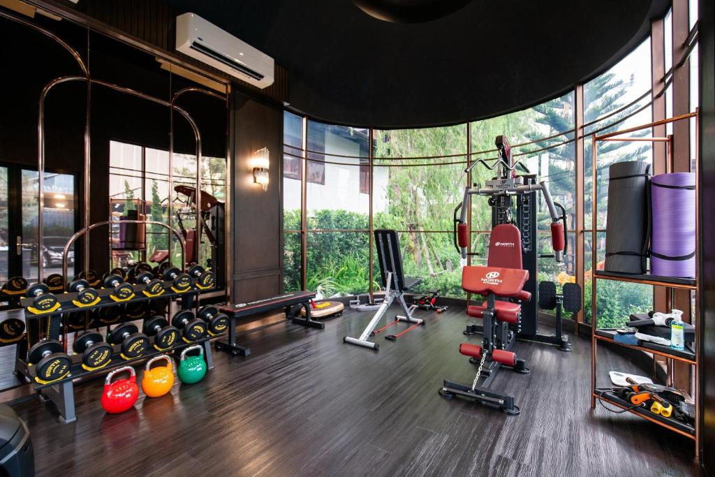 A compact, glass-walled gym with free weights and strength equipment.