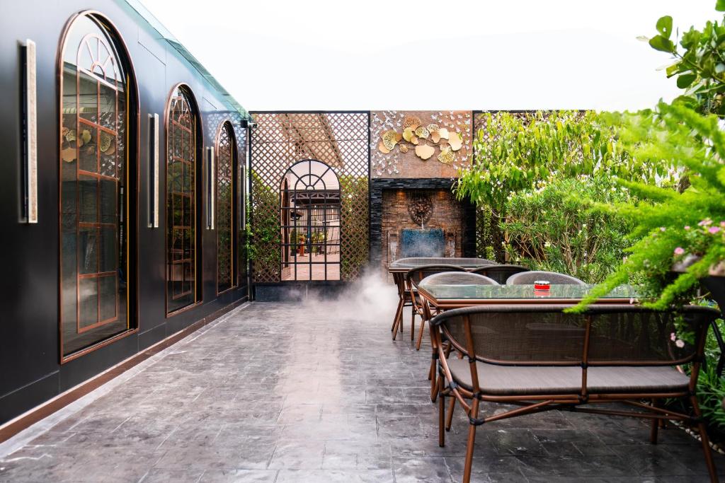 An outdoor dining patio beside a dark, arched-window building.