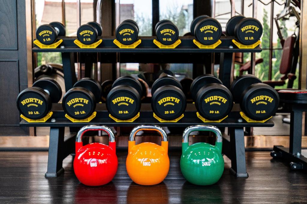 A compact free-weight station with dumbbells and kettlebells.