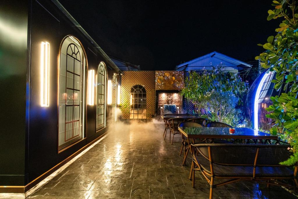 A long, narrow outdoor terrace lined with dining tables at night.