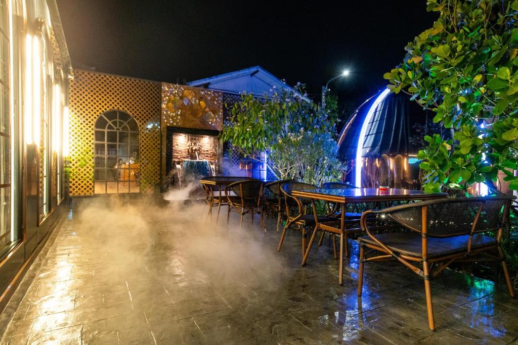 An atmospheric outdoor dining terrace beside illuminated garden features.