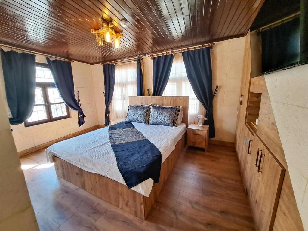 Un dormitorio con una cama grande con cortinas azules. en Levissi boutique hotel, en Gaziantep