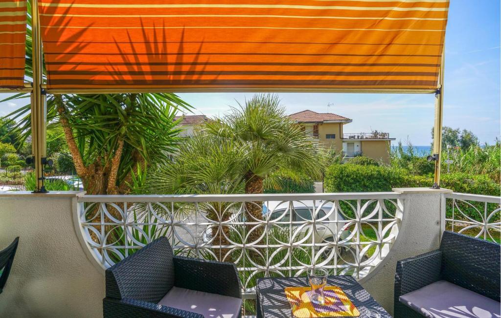 un balcone con due sedie e una tenda arancione di Nice Apartment In Santo Stefano Al Mare a Santo Stefano al Mare