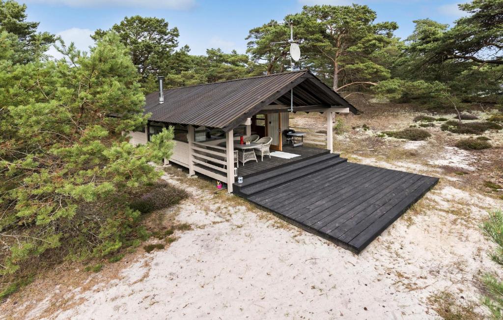 eine Hütte am Strand mit einem Holzdeck in der Unterkunft 2 Bedroom Nice Home In Nexø in Vester Sømarken