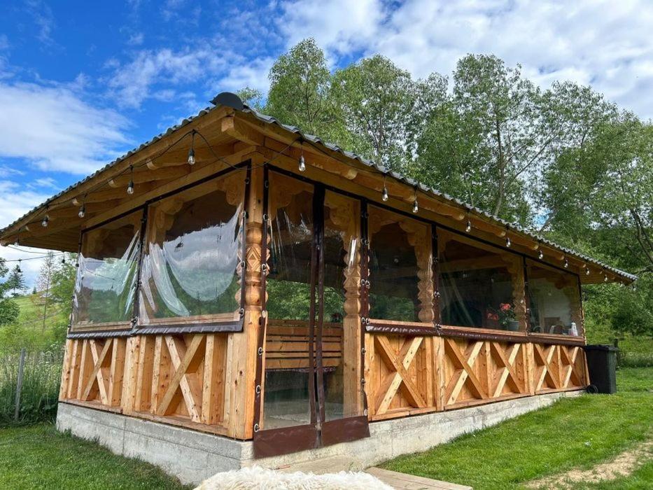 a wooden pavilion with windows in a field at Moldovița Residence in Moldoviţa
