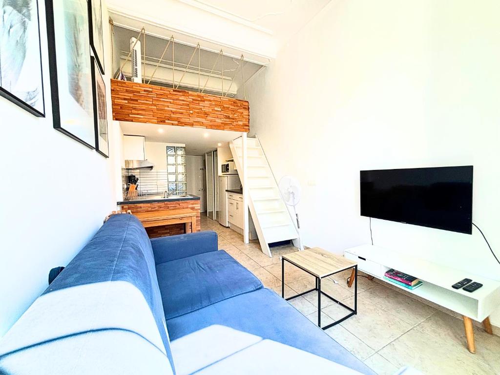 un salon avec un canapé bleu et une télévision dans l'établissement Cosy appart 4pers vieux Nice, à Nice
