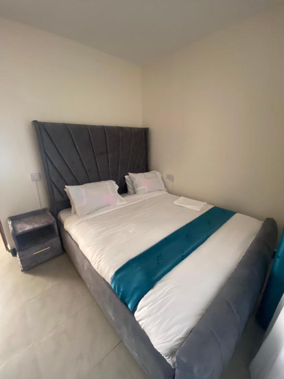 a large bed in a small room with a large mattress at Olive Homes Stylish 3 Bdrm Suites - 07 in Nakuru