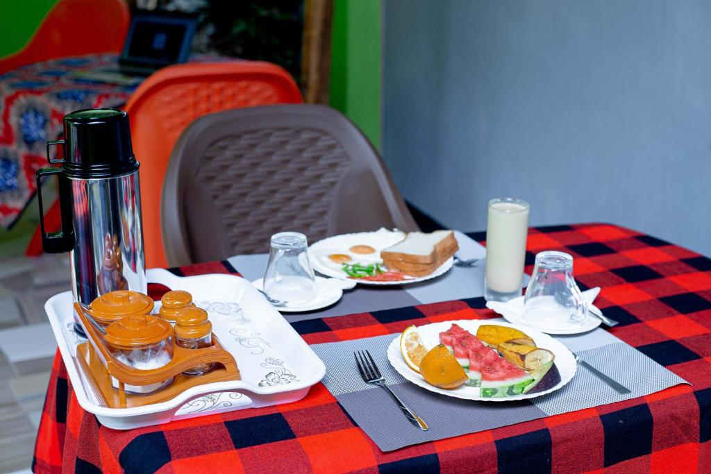 a table with plates of food on a checkered table cloth at L&j modern backpackers BnB in Dar es Salaam
