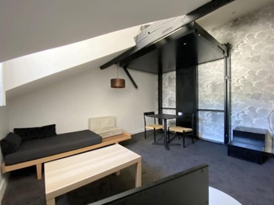 un salon avec un canapé et une table dans l'établissement Superbe studio avec terrasse - Cathédrale, à Nantes