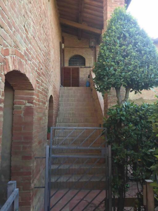 a staircase leading to a brick building with a gate at LA DOGANA . in Siena