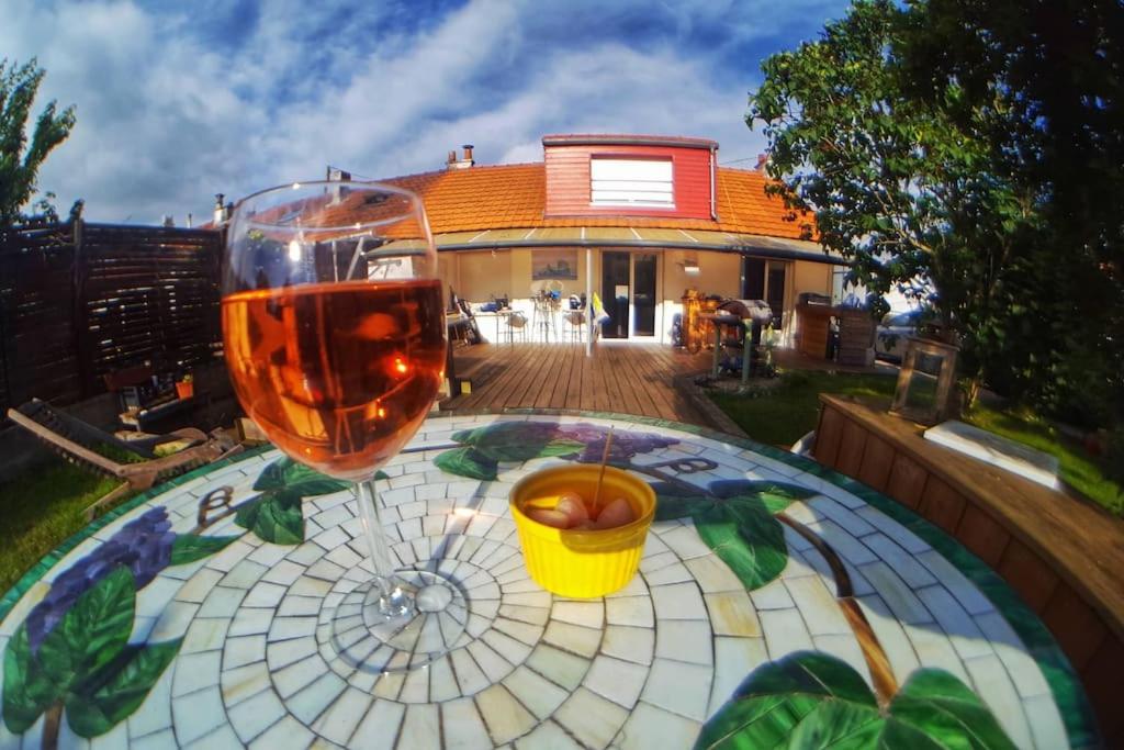 un verre de vin assis sur une table devant une maison dans l'établissement Ma maison pour Vous !!, à La Haie
