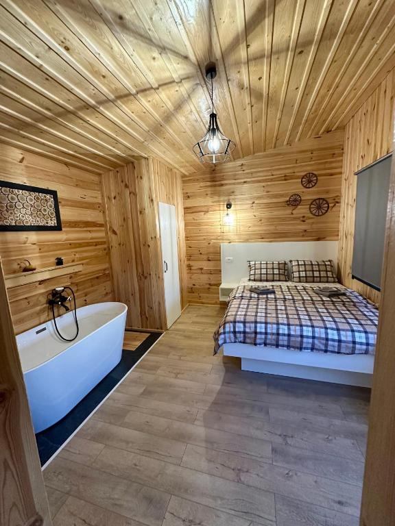 a bedroom with a bed and a bath tub and a bed sqor at Cabană Vinkiș in Măguri-Răcătău