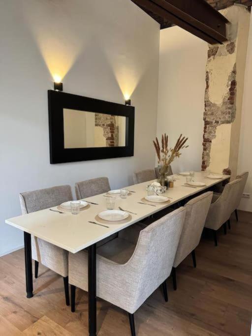 a dining room table with chairs and a long table at Heaven Homes - 15 Gehmin vom Hbf entfernt in Düsseldorf