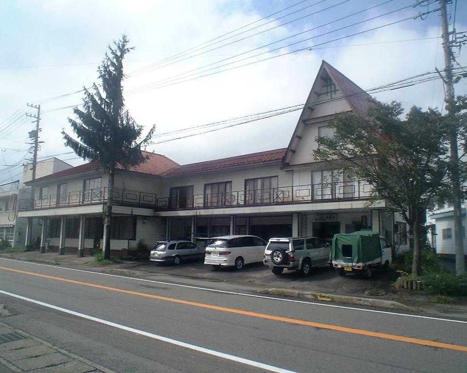 a building with cars parked in front of it at Mizubaso in Gujo