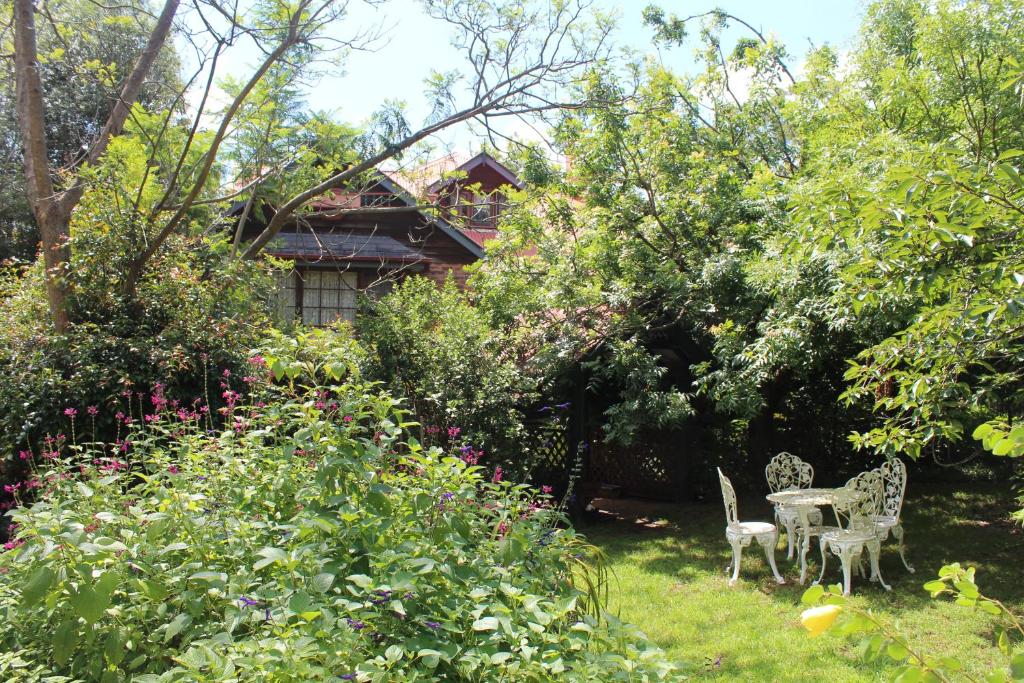 een tuin met 2 stoelen en een tafel en bloemen bij Storey Grange in Springwood