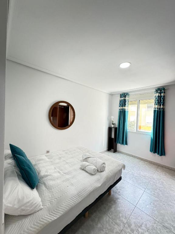 a bedroom with a bed with a mirror and blue curtains at Habitacion privada in Valencia